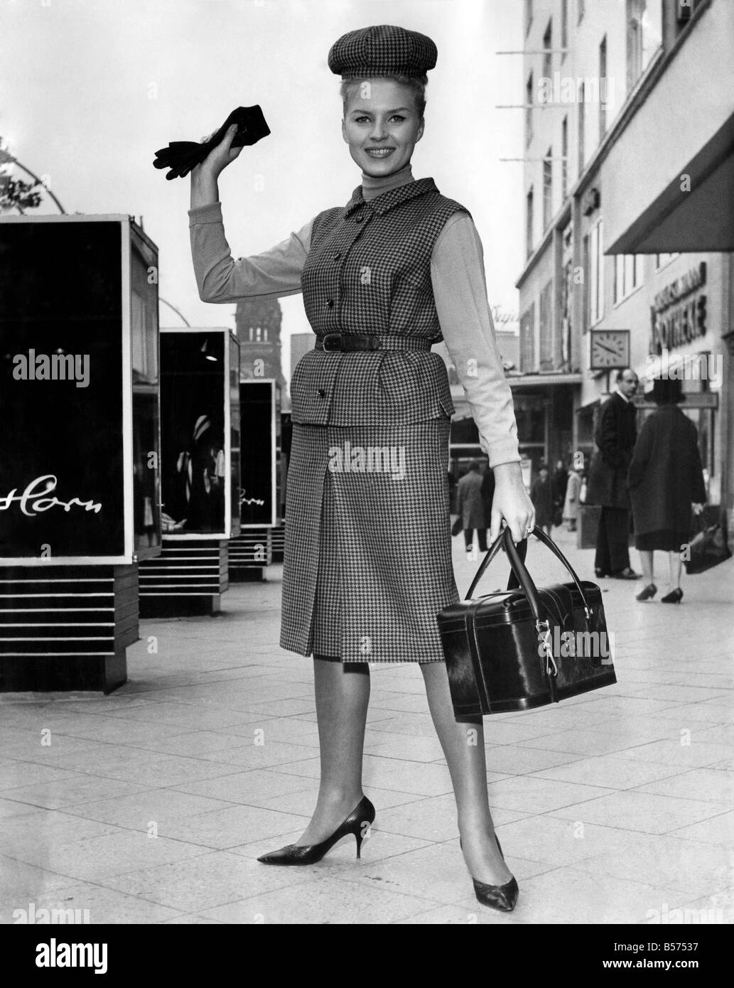 Kleidung von 1963. Frau trägt ein Tweed-Jacke und Rock mit Handtasche und Handschuhe.  November 1963 P009451 Stockfoto