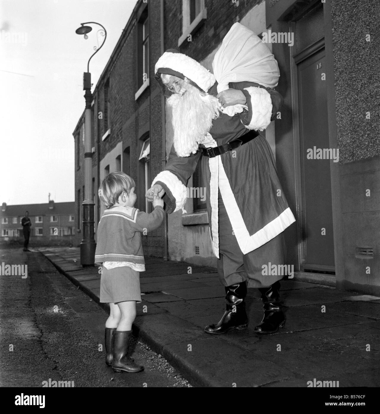 Eine ältere Frau als Weihnachtsmann verkleidet auf dem Weg zur Verlobung von Nachbarskinder begleitet. Dezember 1969 Z11977 Stockfoto