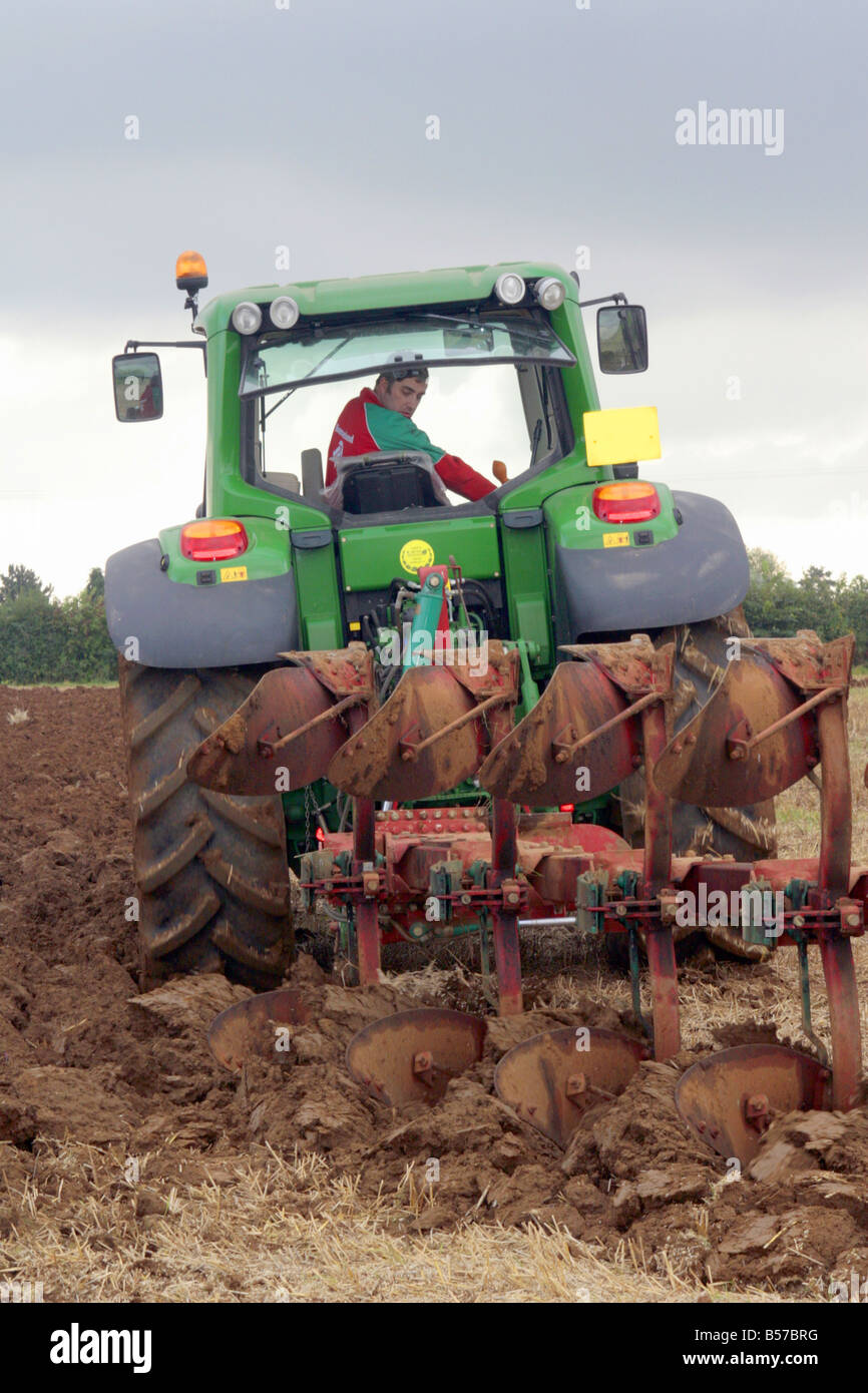 Ein Bauer bei der Arbeit, Pflügen ein Feld mit einem reversiblen Pflug. Stockfoto