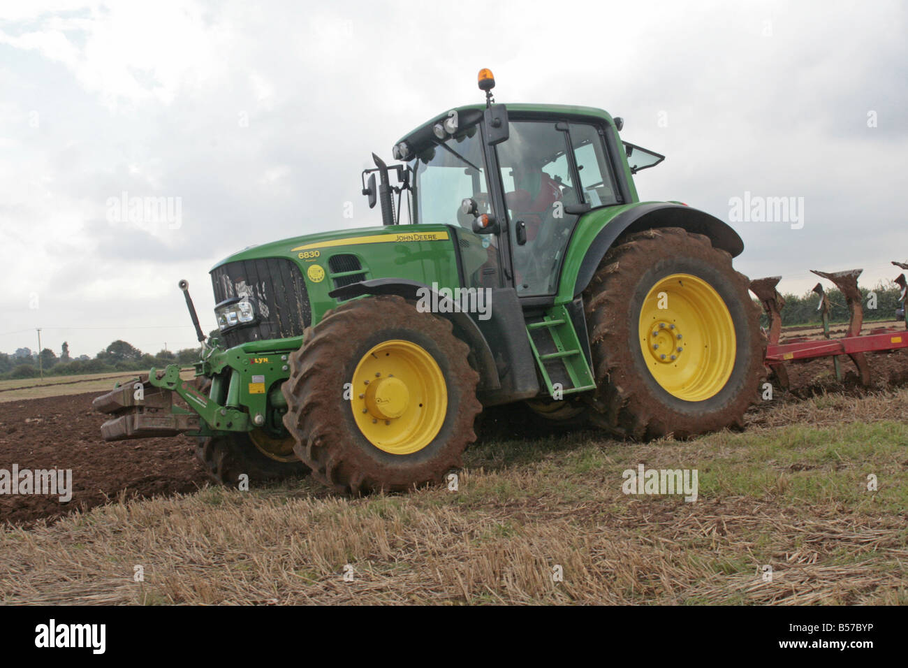 Ein Bauer fährt einen John Deer Traktor beim Pflügen seines Fachs. Stockfoto