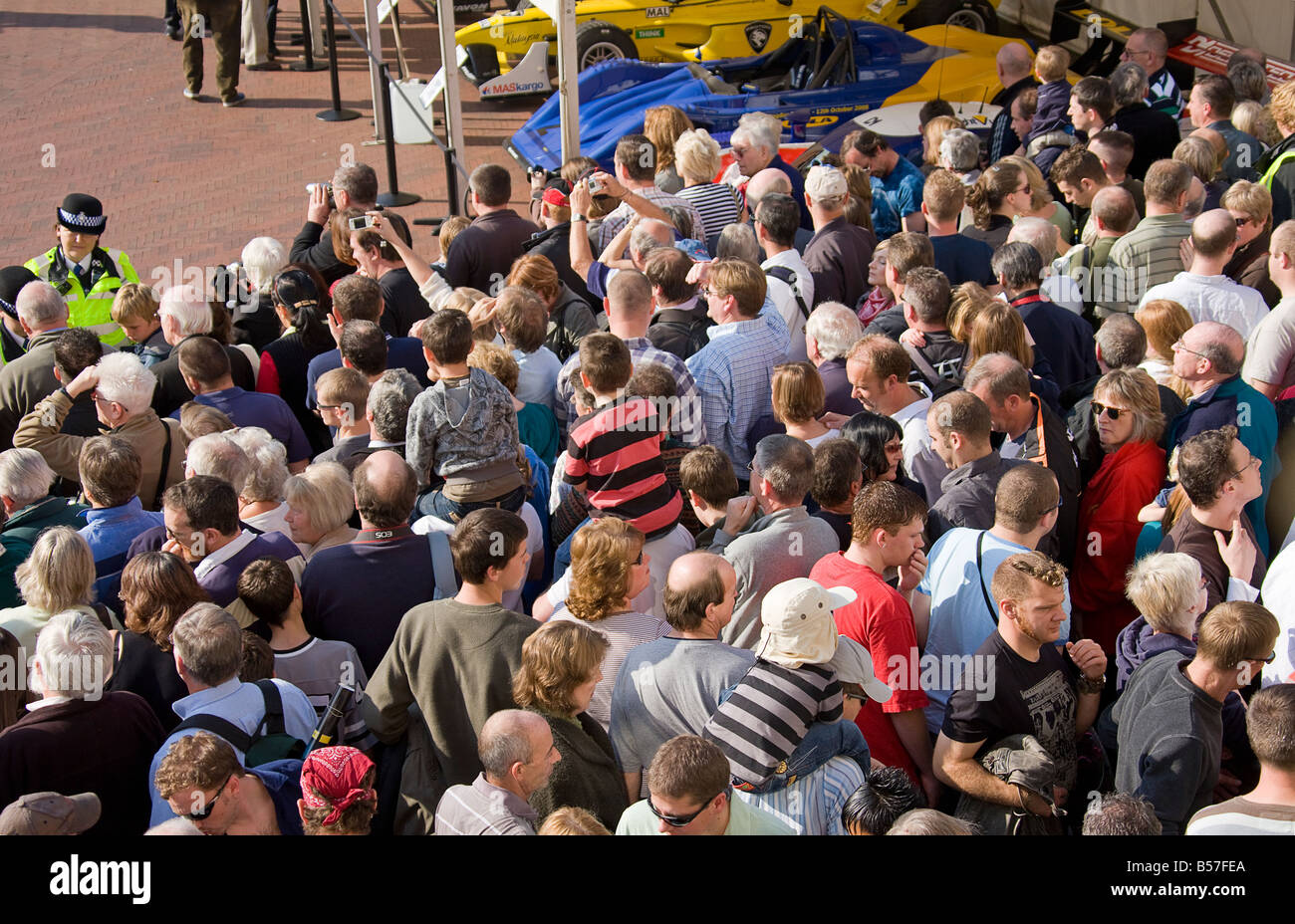 Einige der Hugh Menschenmenge, zurückgehalten wird durch die Barriere und die Polizei, während des Wartens auf in die Arena zu bekommen, um die Autos zu sehen Stockfoto