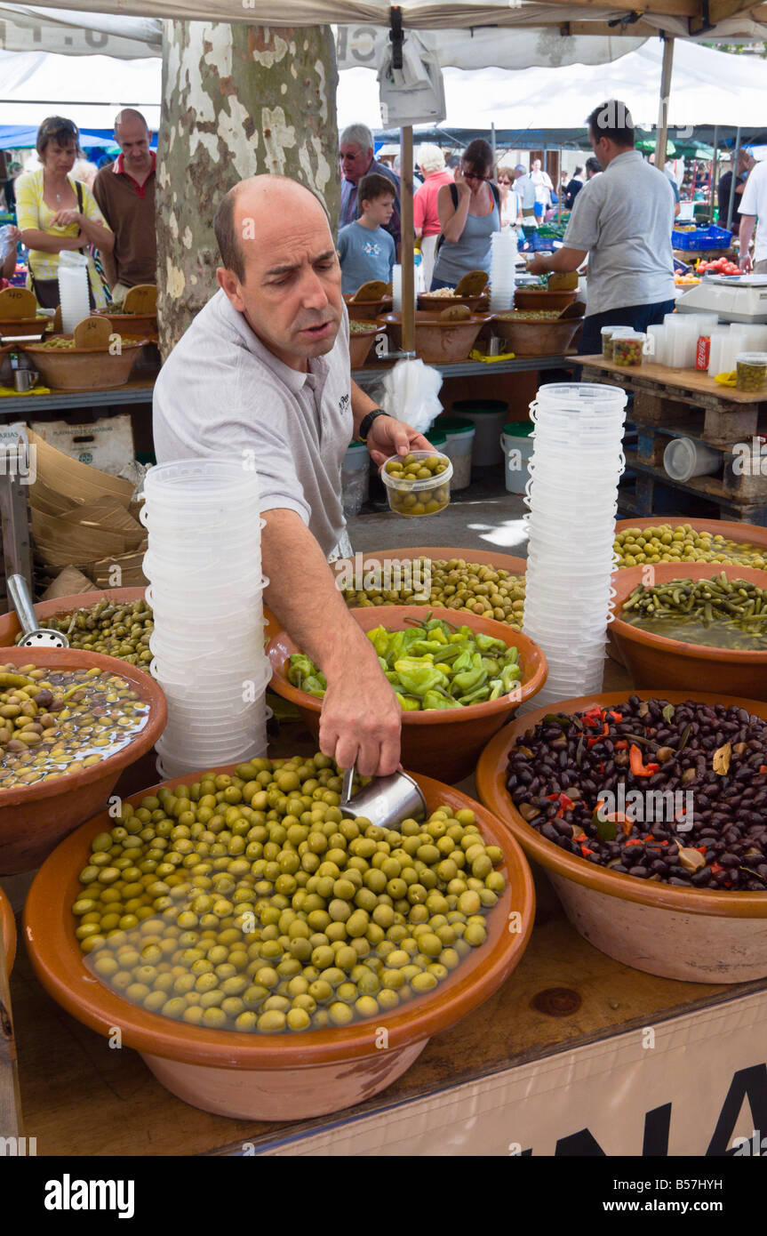 Ein Mann, der Verkauf von Oliven auf einem Marktstand Pollensa, Mallorca, Spanien. Stockfoto