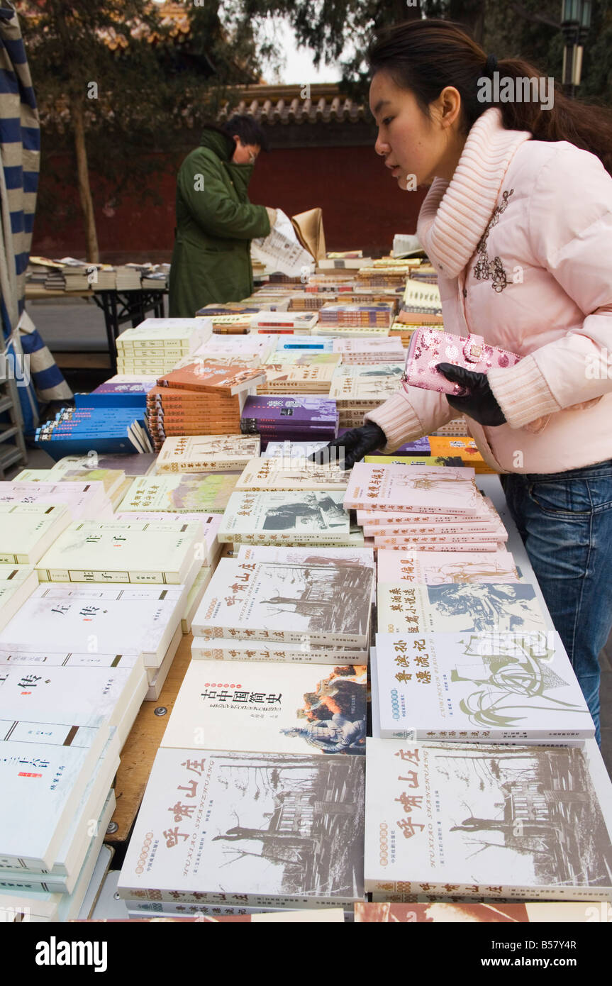 Ein chinesisches Mädchen auf der Suche nach Büchern im Ditan Park Buch Messe, Peking, China, Asien Stockfoto