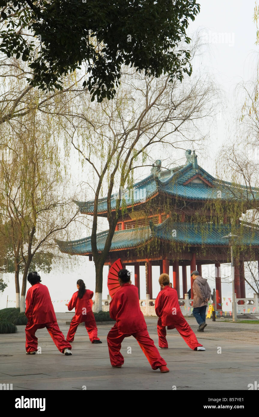Frauen üben Tai Chi vor einem Pavillon am Westsee, Hangzhou, Zhejiang Province, China, Asien Stockfoto