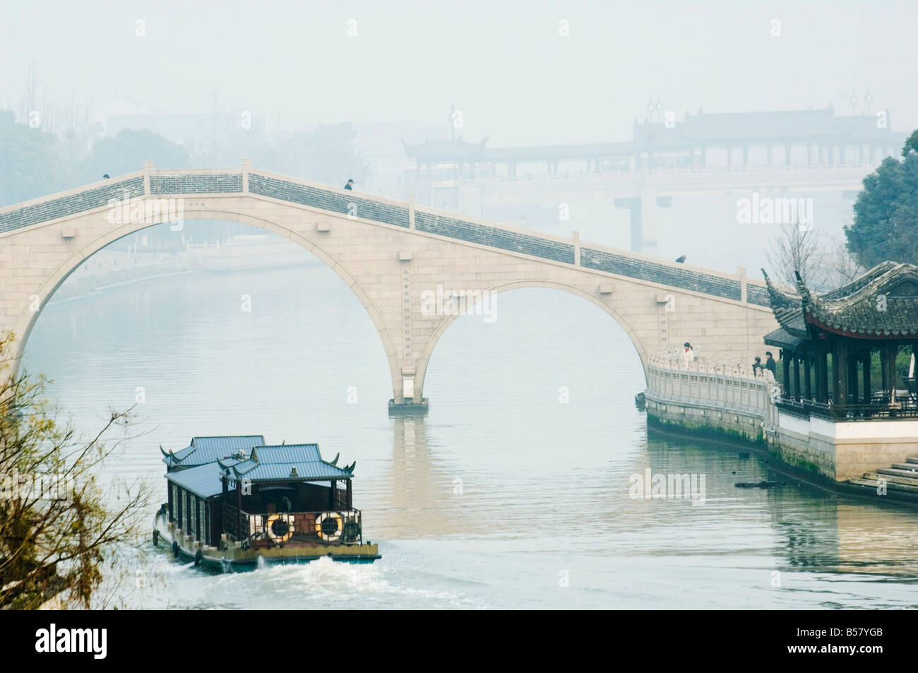 Ein Boot durch einen Stein gewölbten Brücke am Fluss Waicheng mit Wumen Brücke hinter Suzhou, Jiangsu Provinz, China, Asien Stockfoto