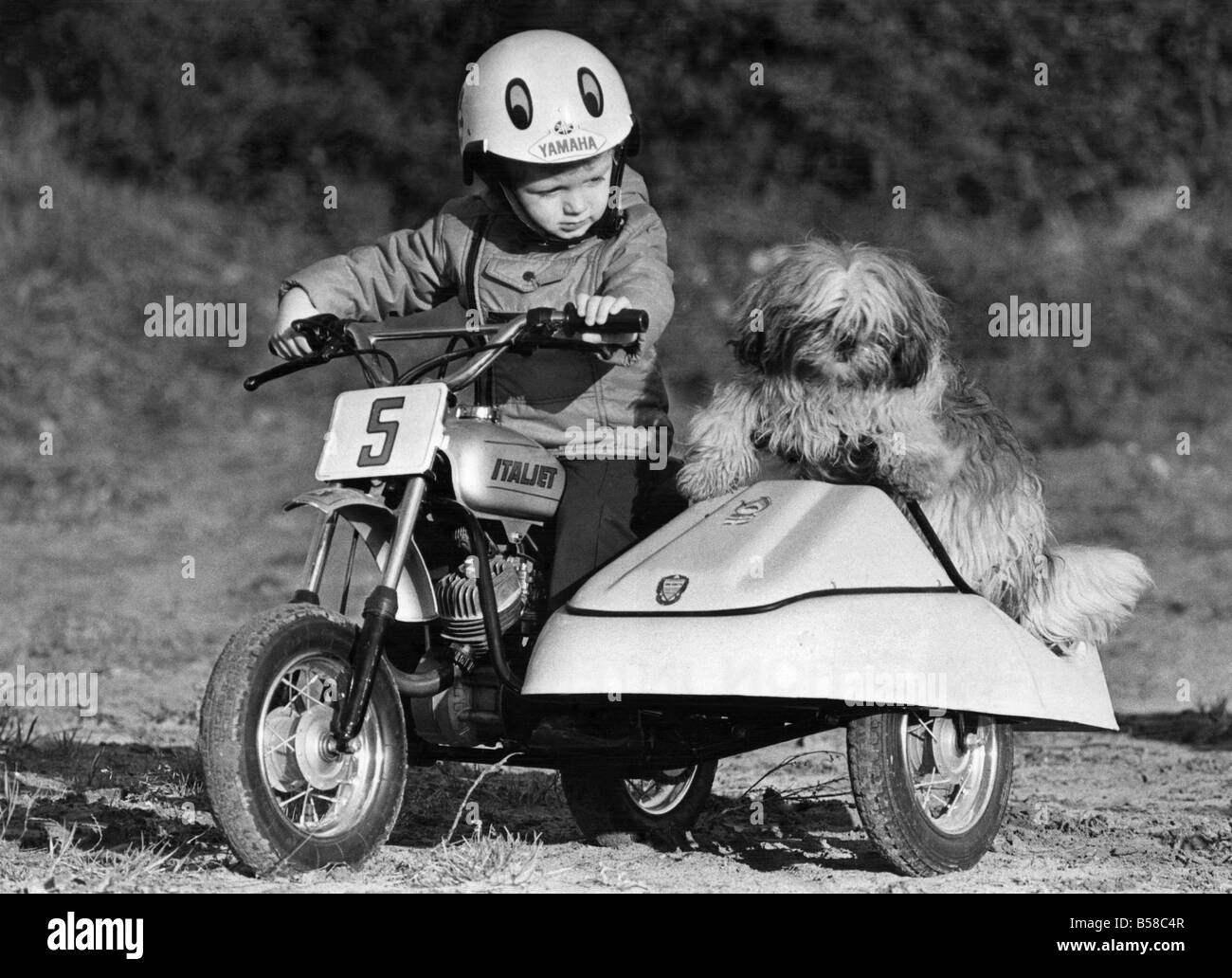 Vroom... Eine Tonne Kind: Motorrad Kind Jason mag klein sein, aber er ist schnell. Da sein Vater, ehemaligen Rennen-Ass Jim Smyth, ihm ein Motorrad gekauft, ist er sozusagen in eine richtige kleine Tearaway verwandelt. Eine Variante des Gashebels auf seiner 47 cc italienischen Mini-Maschine und die süße Musik schickt ihn Rennen aus einem ratternden 5 mph. Und das macht Sie ein Bühnenbekleidung Kind bist du nur zwei. Aber seinen Hund Buddy Grenze ist nur 4 km/h. etwas schneller und er eilt aus dem Beiwagen. Dezember 1976 P006095 Stockfoto