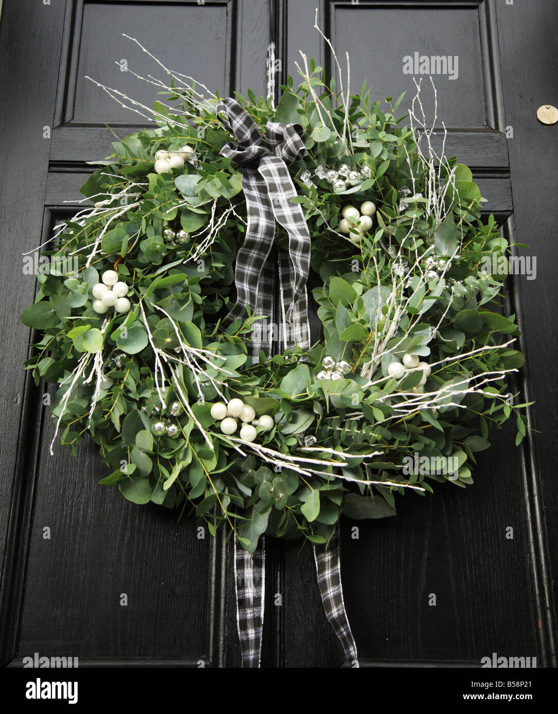 Eukalyptus-Adventskranz hing an einem schwarzen Tor Stockfoto