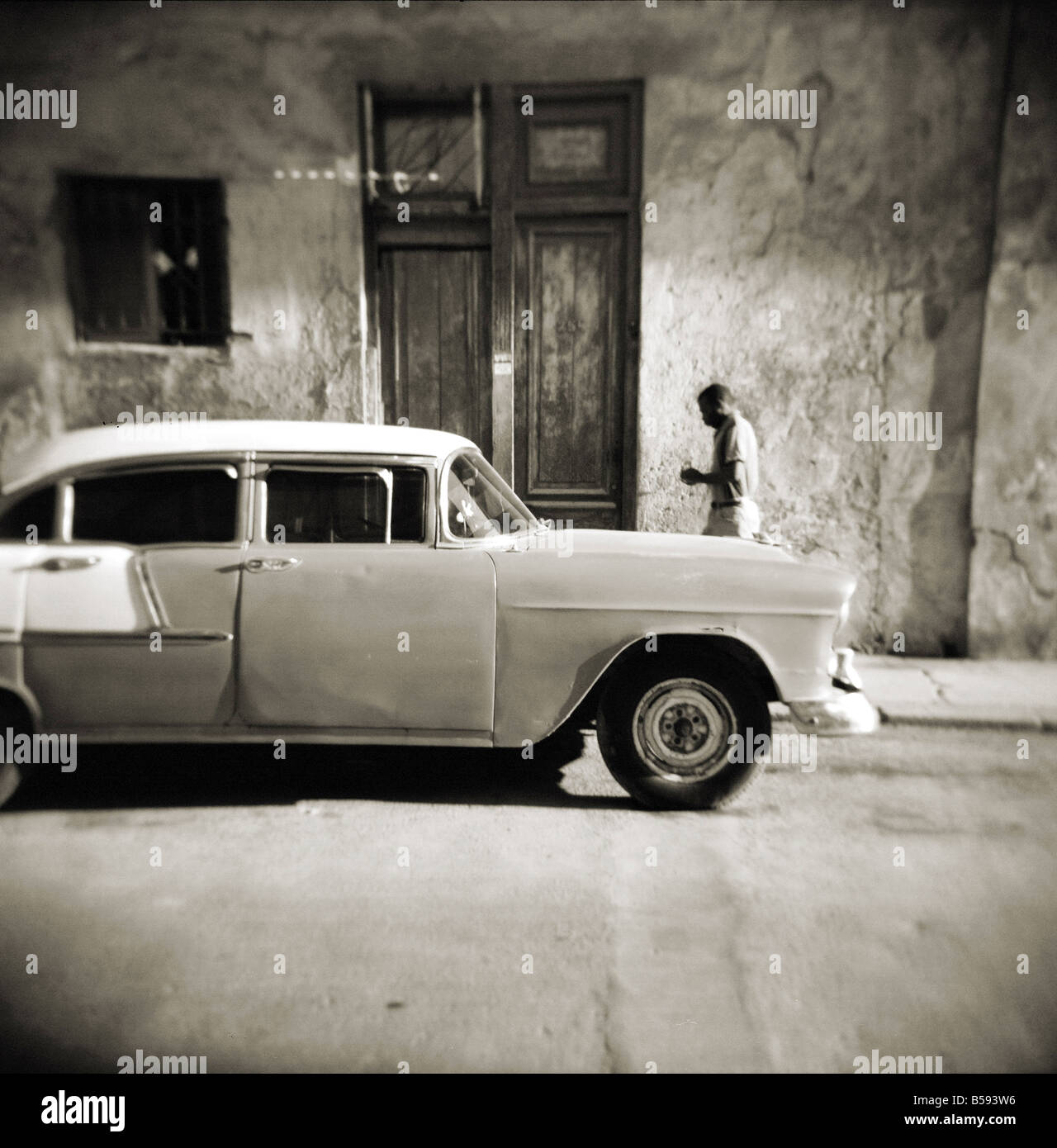 Bild aufgenommen mit einer Holga Mittelformat 120 Film Spielzeugkamera der Mann zu Fuß vorbei an alten amerikanischen Auto, Havanna, Kuba, Westindische Inseln Stockfoto