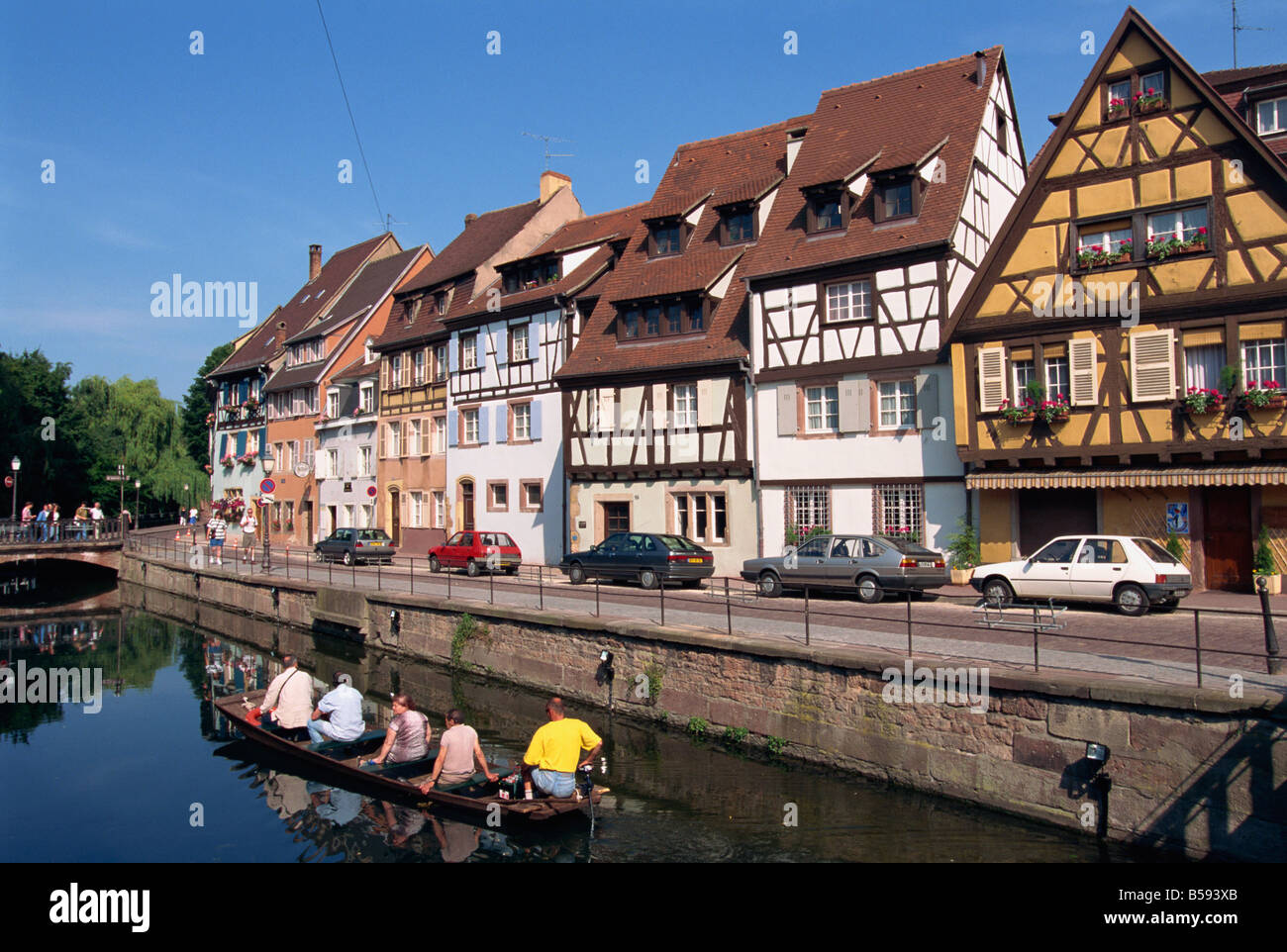 Touristen in kleinen Boot neben dem Quai De La Poissonnerie von Fachwerkhäusern im Elsass von Colmar übersehen Stockfoto