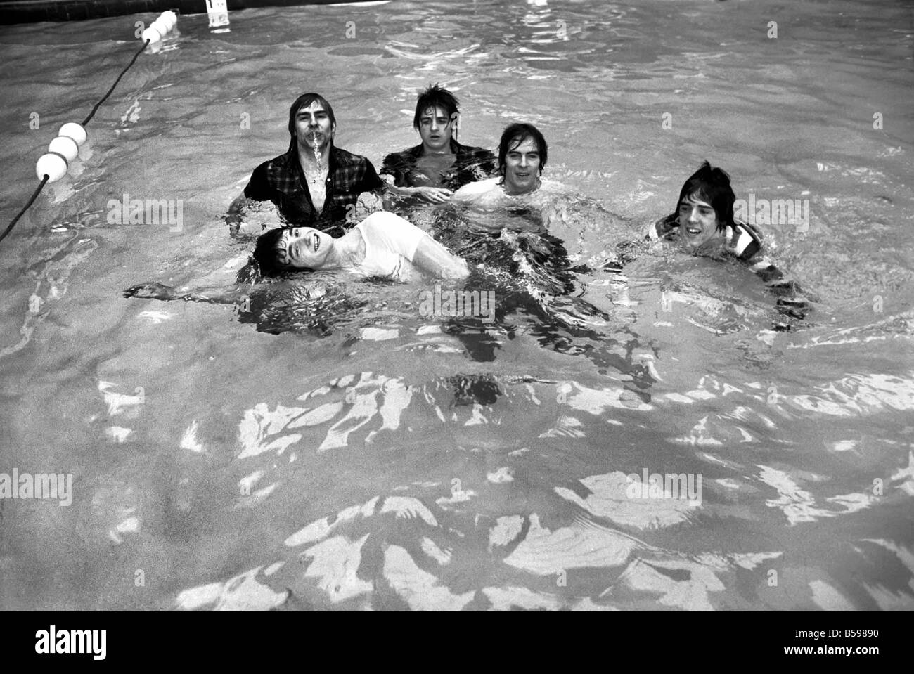 Die Bay City Rollers feiern ihren Chart-Erfolg mit einem schnellen Sprung in den Pool. Die Rollen sind schottische Pop/Rock-Band... Ihre Stockfoto Die Bay City Rollers feiern ihren Chart-Erfolg mit einem schnellen Sprung in den Pool. Die Rollen sind schottische Pop/Rock-Band... Ihre Stockfoto