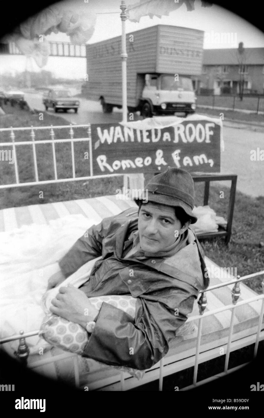 Romeo Meli kauerte gegen Zurrgurte Regen in einem Bett, wie Lastwagen vorbei rollte. Er ist auf Rasen Arbeitsteilung eine zweispurige Weg in einem Versuch, seinen Untergang geweihten Hütte sparen dösen. Er ist der letzte Mann links zu trauern, die Weitergabe von der verlassenen Groes in der Nähe von Port Talbot, Glam. Die anderen 21 Familien sind bereits Weg ausgezogen. April 1975 75-1947-003 Stockfoto