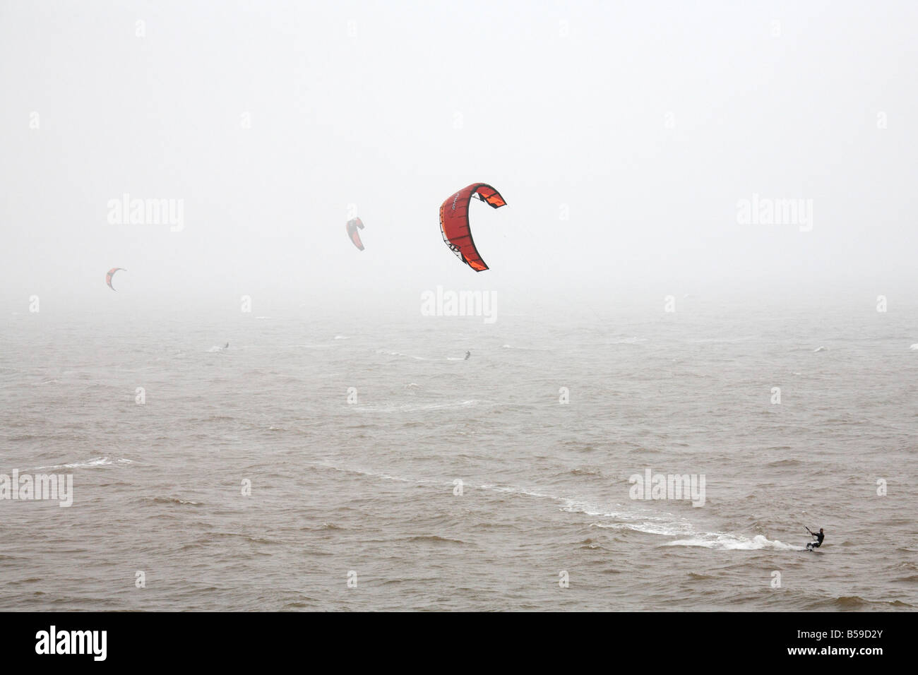 Menschen-Kite-Surfen auf dem Meer im Nebel in Freshwater Bay Isle Of Wight England UK Stockfoto