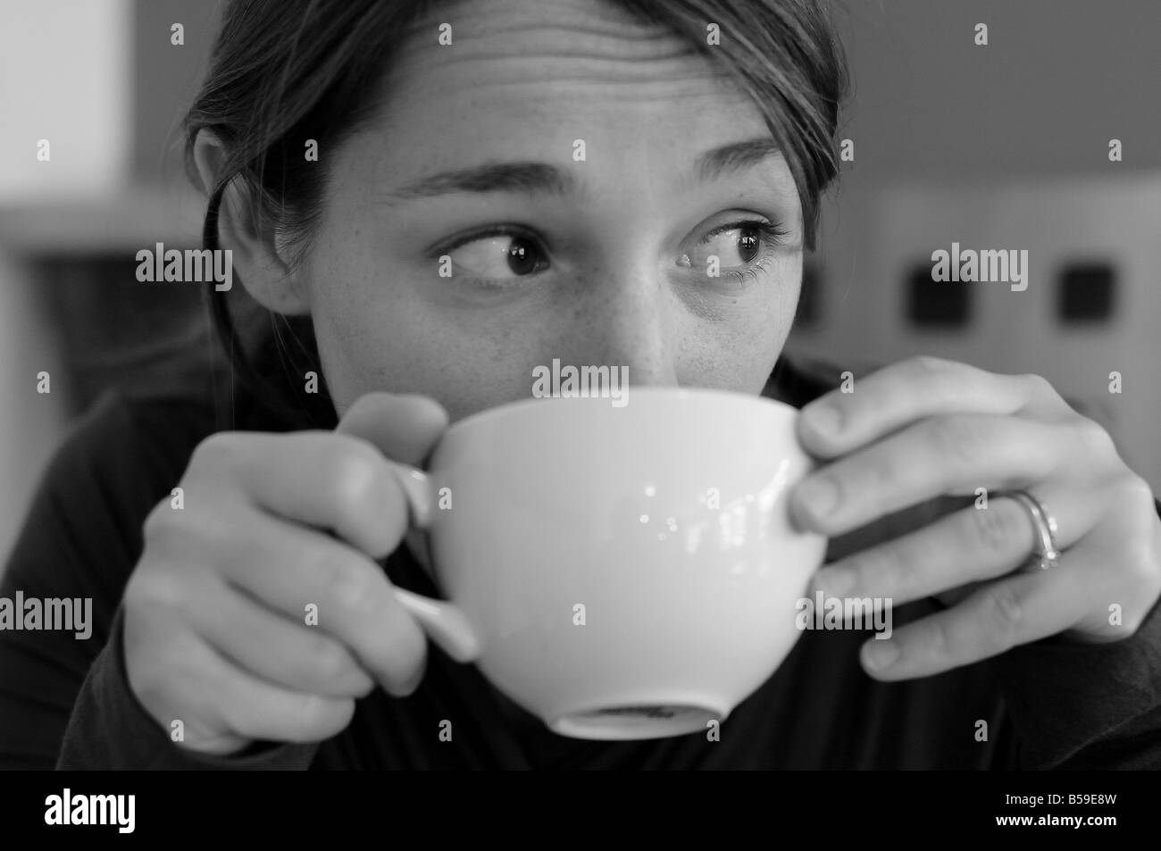 Schwarz / weiß Foto einer Frau, die ihre morgendliche Tasse Kaffee zu trinken. Stockfoto