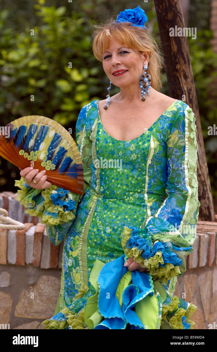 Schöne blonde mittleren gealterten spanische Frau in traditioneller Tracht mit Ventilator (Abanico) Costa Del Sol, Andalusien, Spanien Stockfoto