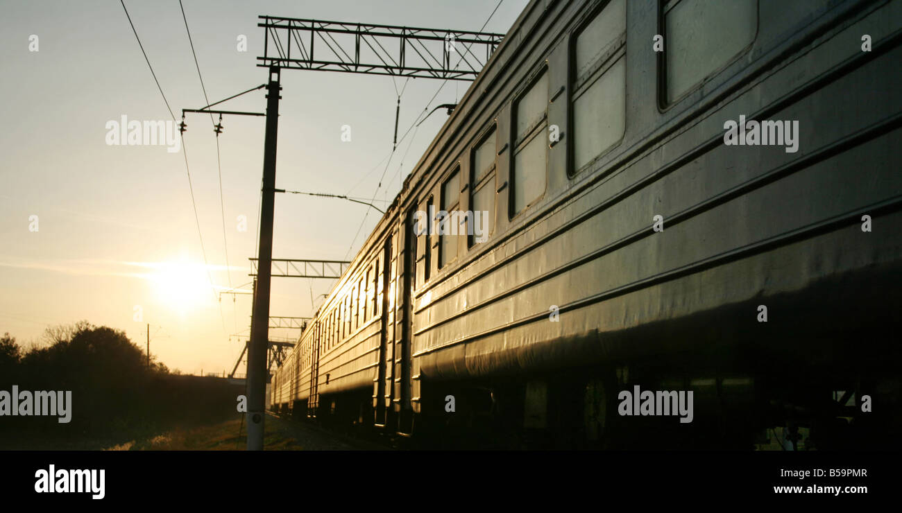 Zug auf der Bahnstrecke im Sonnenuntergang Stockfoto
