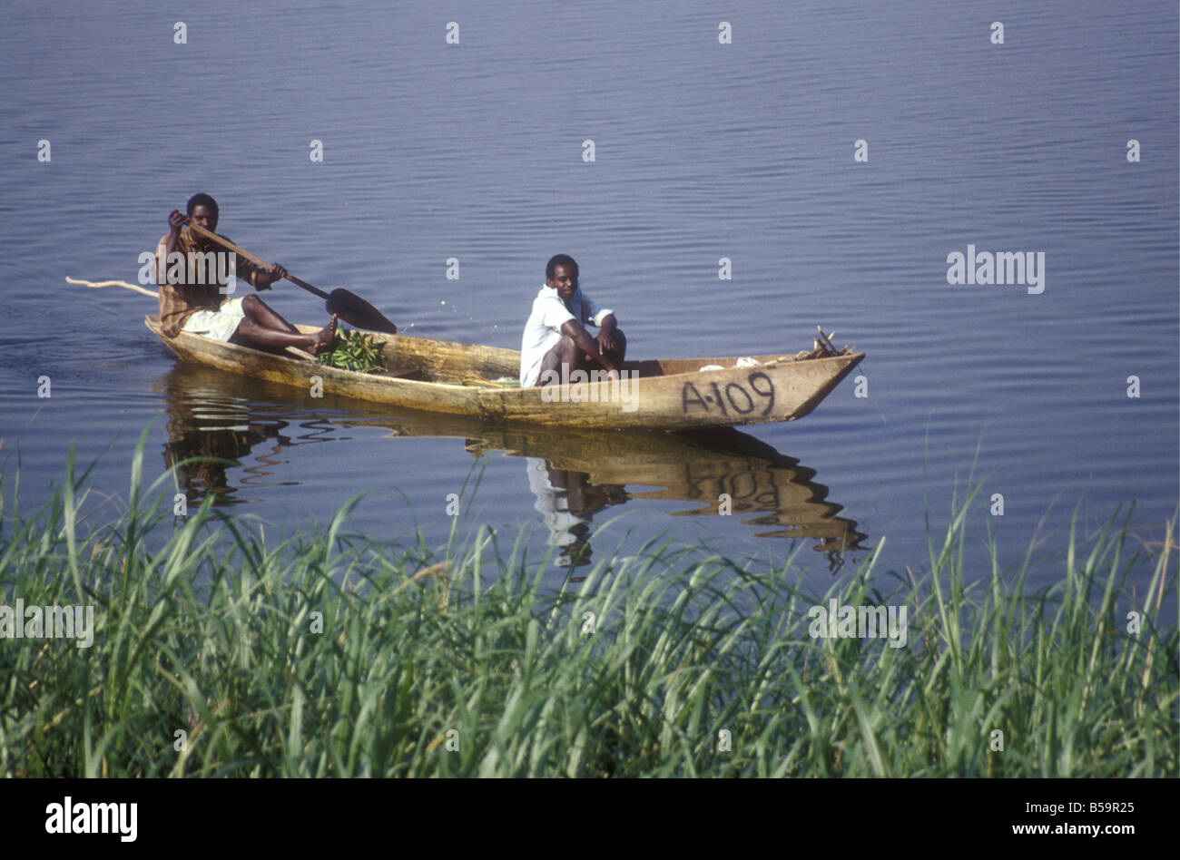 Zwei schwarze Afrikanerinnen Fischer ihre hölzernen paddeln ausgegraben Kanu auf Hütte Kanal Süd-west-Uganda Stockfoto
