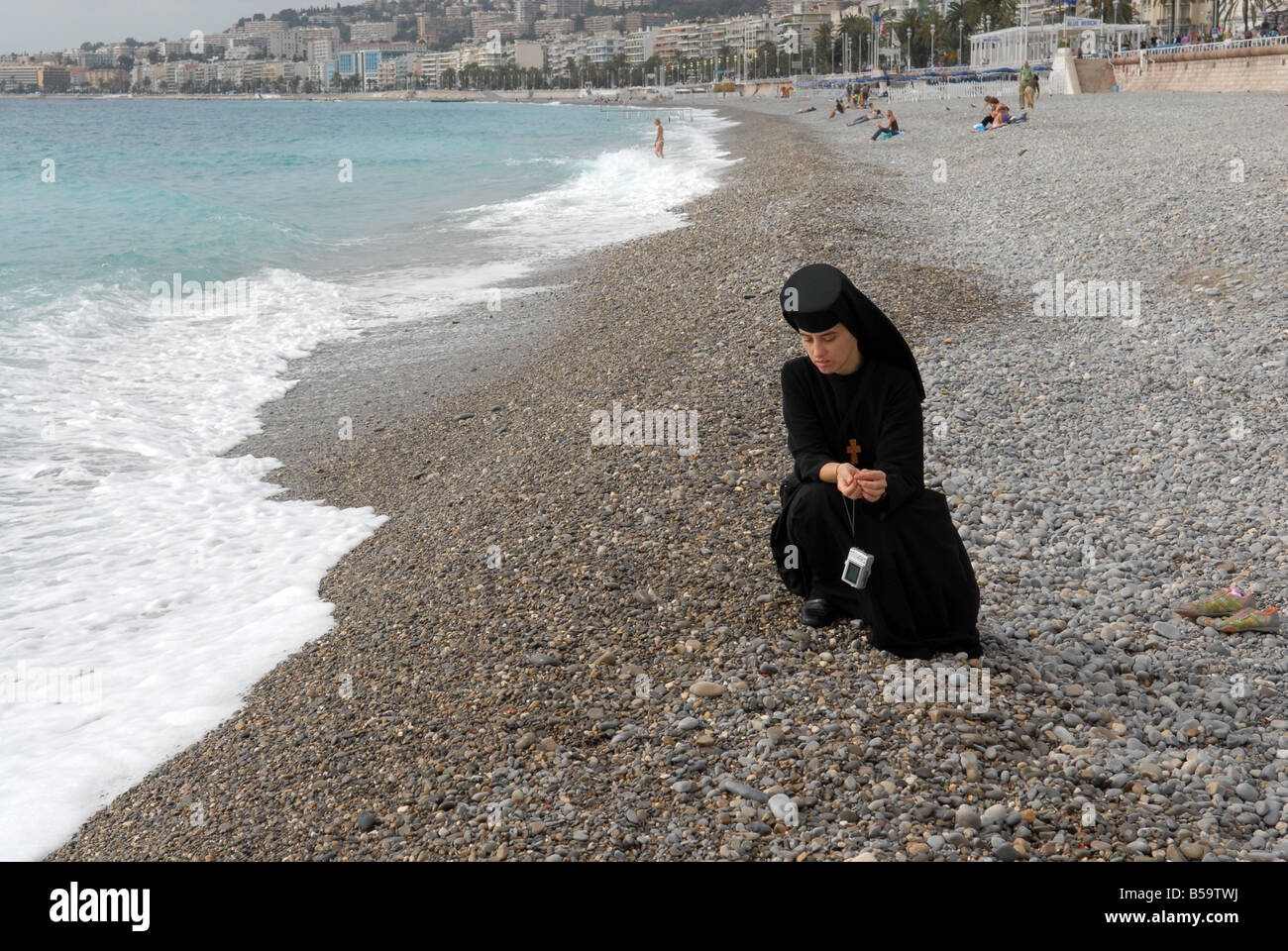 Eine orthodoxe ukrainische Nonne mit ihrer Digitalkamera am Strand in Nizza in Südfrankreich. Bild von DAVID BAGNALL Stockfoto