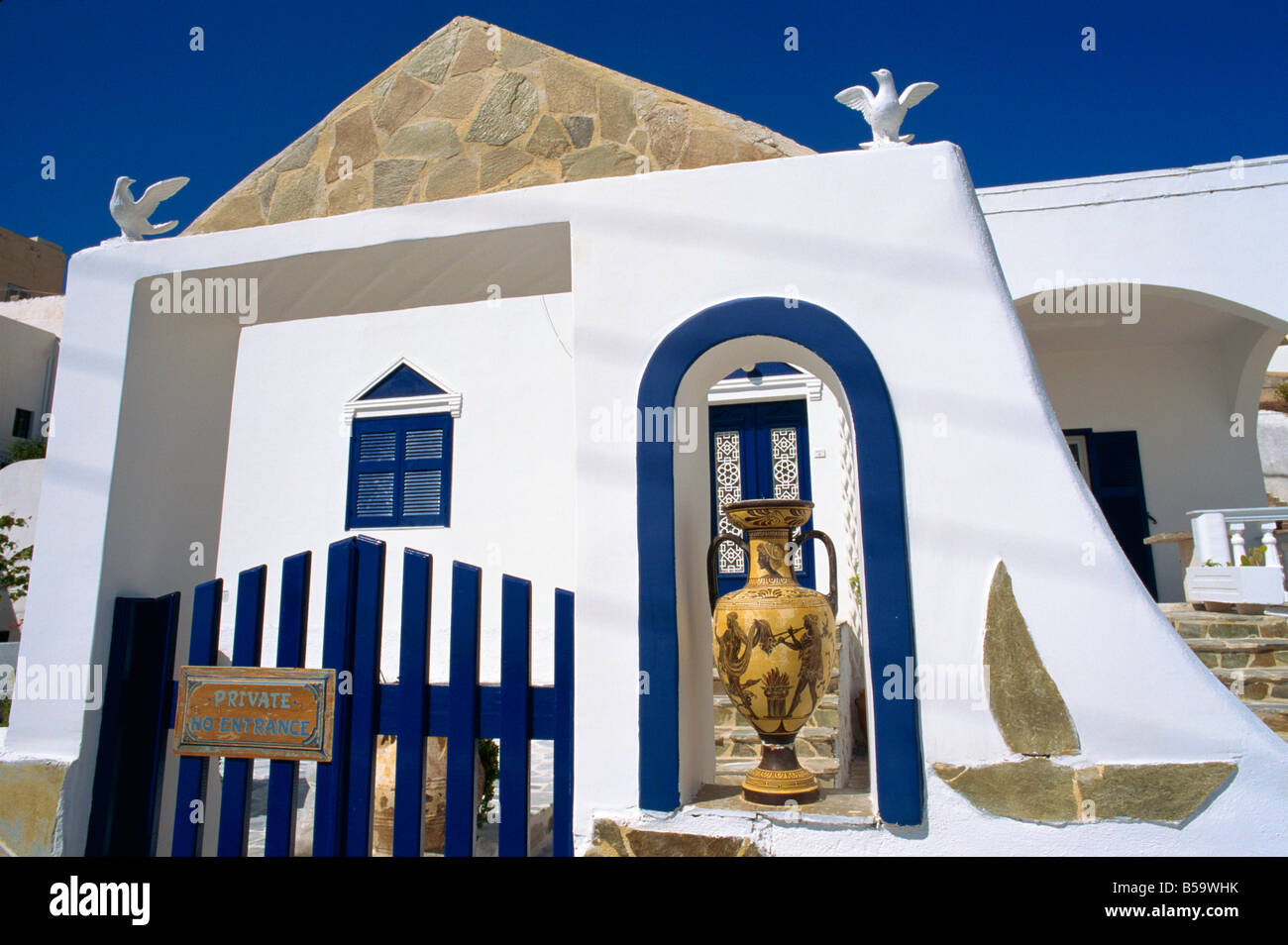 Privathaus mit weißen Wänden, blaues Tor und Urne, Stadt Fira, der Hauptstadt von Santorini (Thira), Kykladen, Griechenland Stockfoto