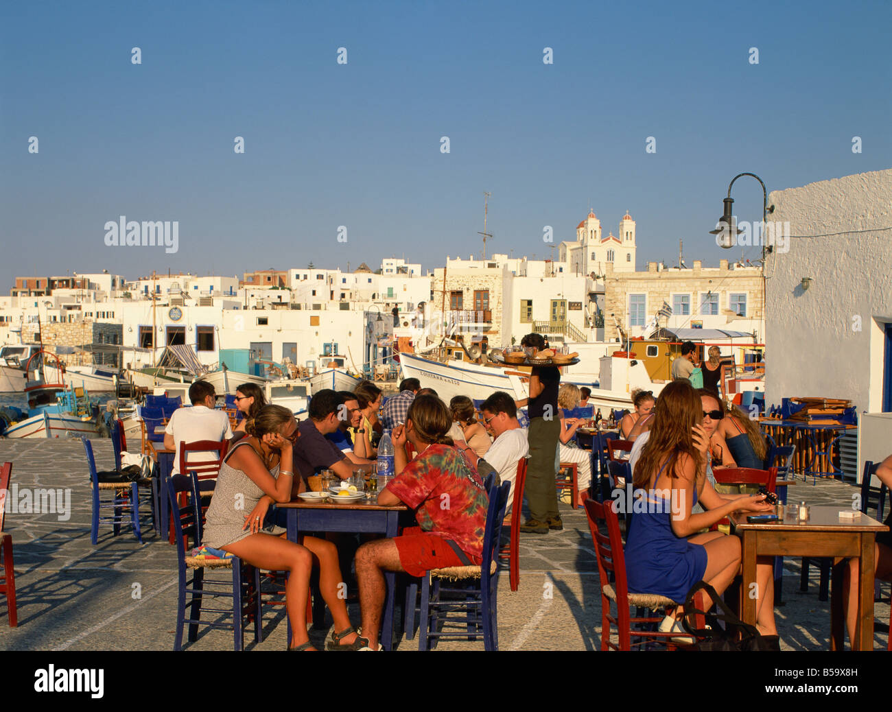 Touristen, Essen und trinken außerhalb in einer Taverne in der Stadt Naoussa auf Paros Kykladen griechische Inseln Griechenland Europa Stockfoto