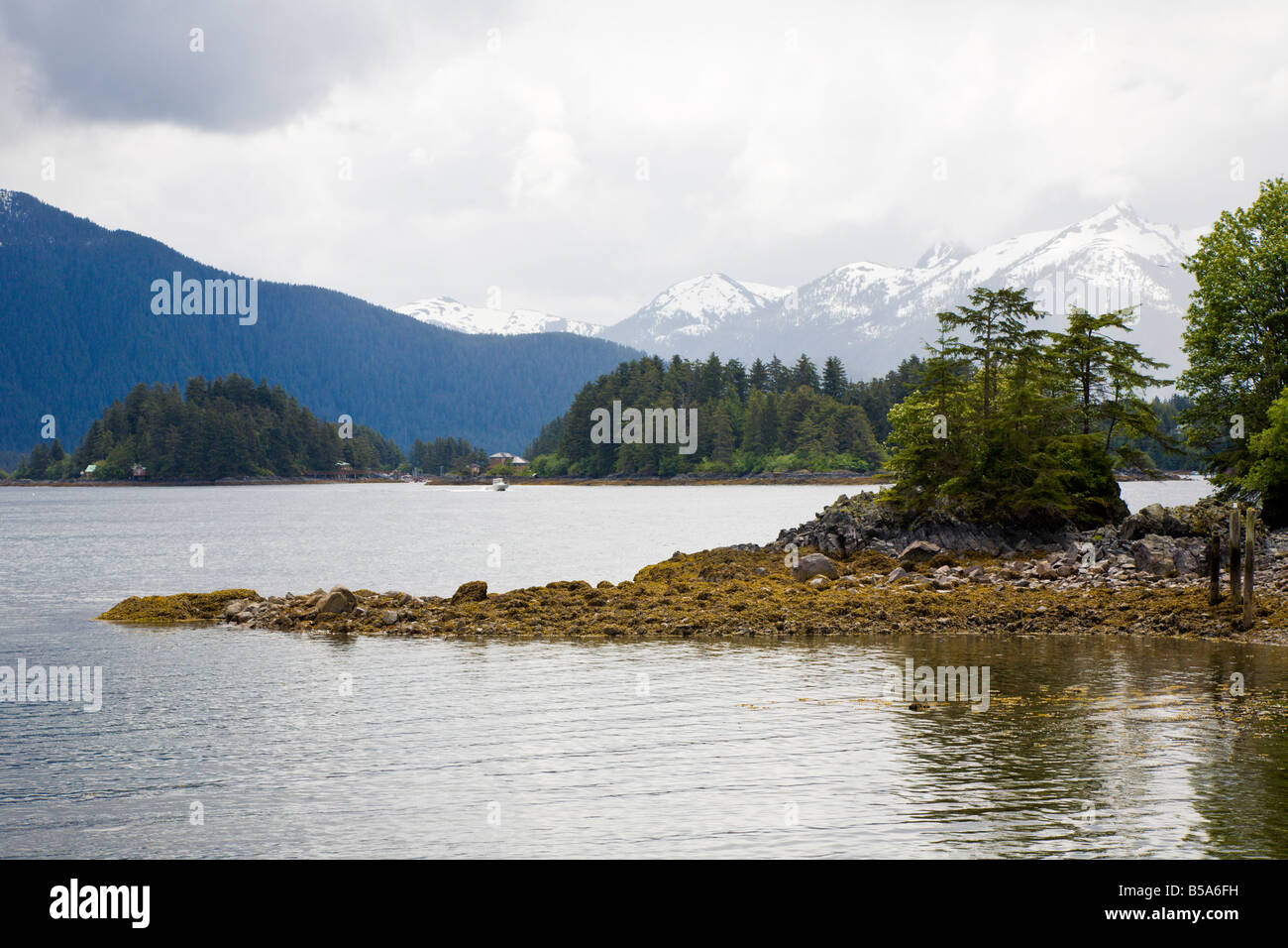 Felsige Küste und Snow capped Berge in der Nähe von Sitka, Alaska Stockfoto