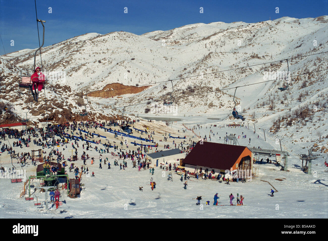 Frau mit Sessellift über Massen von Skifahrer und Touristen am Neve Ativ Skigebiet am Mount Hermon, Israel, Nahost Stockfoto