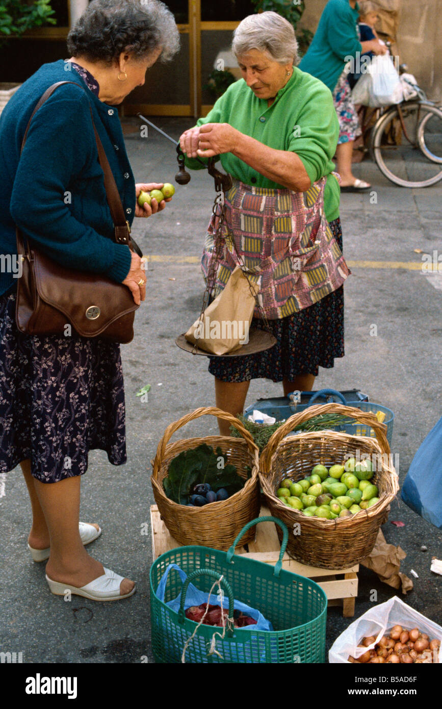 Frau verkaufen Feigen mit einem altmodischen Gleichgewicht auf dem Markt von Pescia in Toskana Italien M Newton Stockfoto