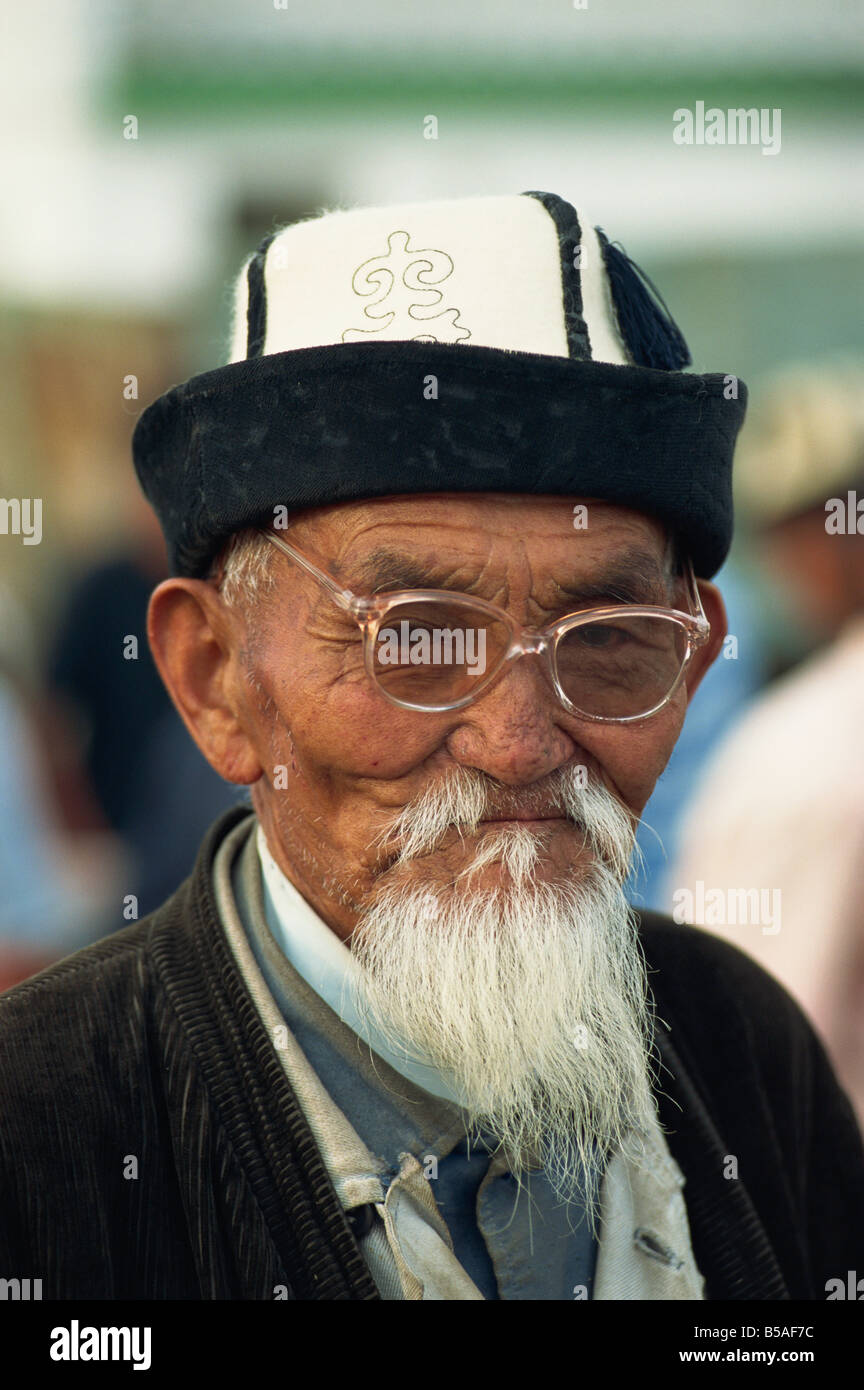 Porträt eines alten Mannes der Kirgisen mit weißen Bart Filz Hut und Brille auf dem Pferdemarkt in Balikchi in Kirgisistan Zentralasien Stockfoto