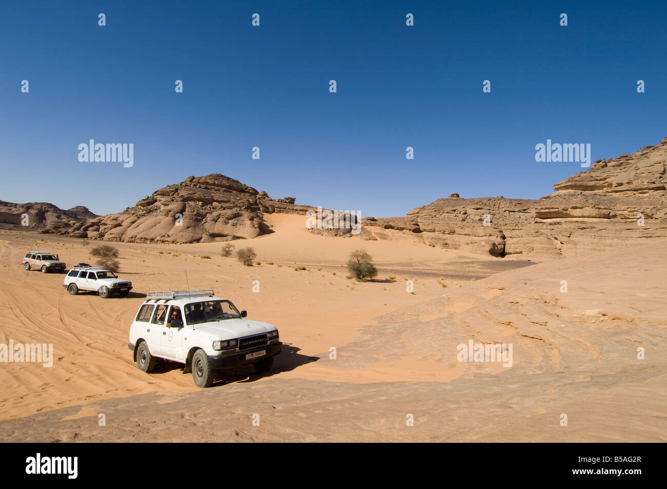 SUV Klettern Fels, Akakus, Sahara Wüste, Fezzan, Libyen, Nordafrika, Afrika Stockfoto