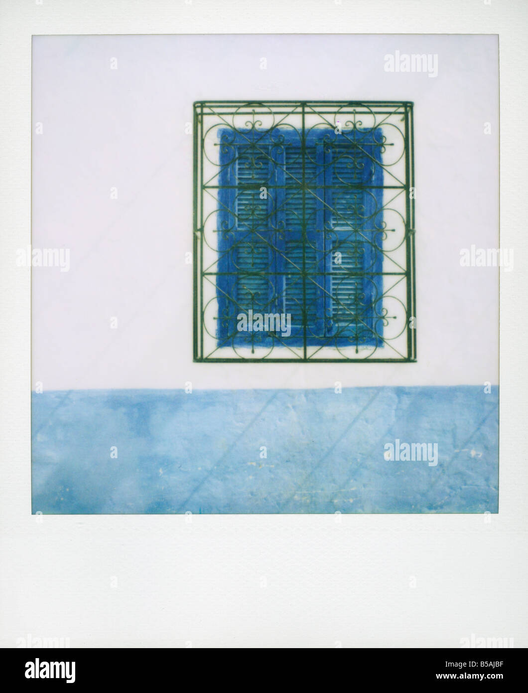 Polaroid weiß getünchte Wand mit blauen Fensterläden und Eisengitter Asilah Marokko Nordafrika Afrika Stockfoto