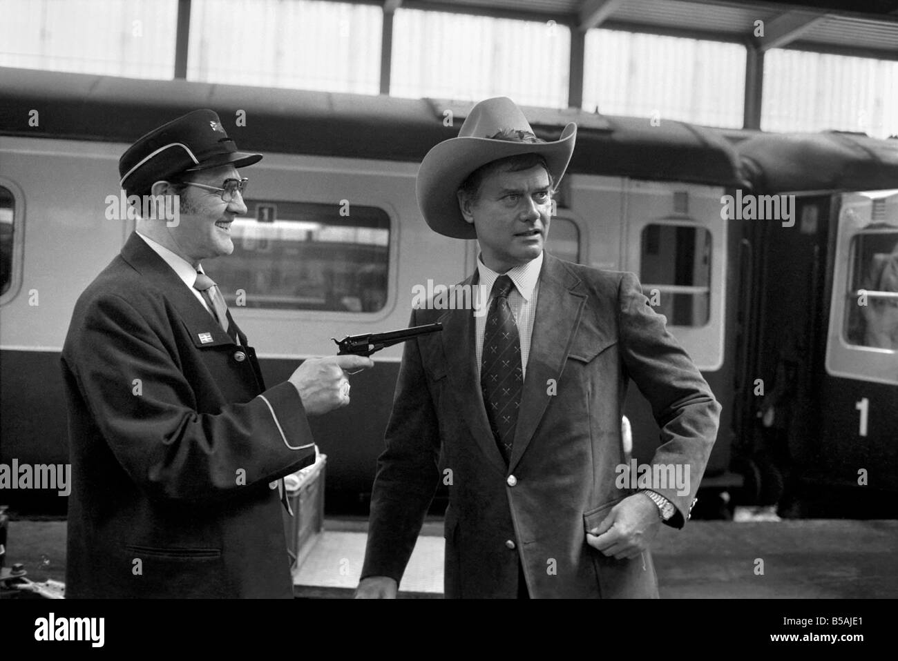US-amerikanischer Schauspieler Larry Hagman, J. R. Ewing in der TV-Serie Dallas, in ein weiteres Elfmeterschießen mit einem British Rail Porter spielt, eine Stockfoto
