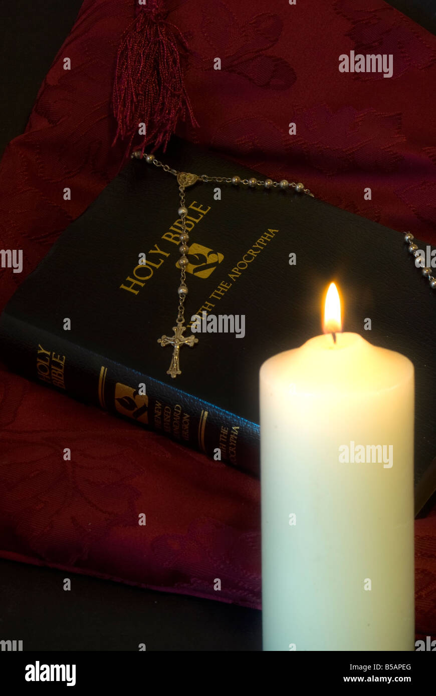 Leuchtende Kerze Bibel Rosenkranz Stockfoto