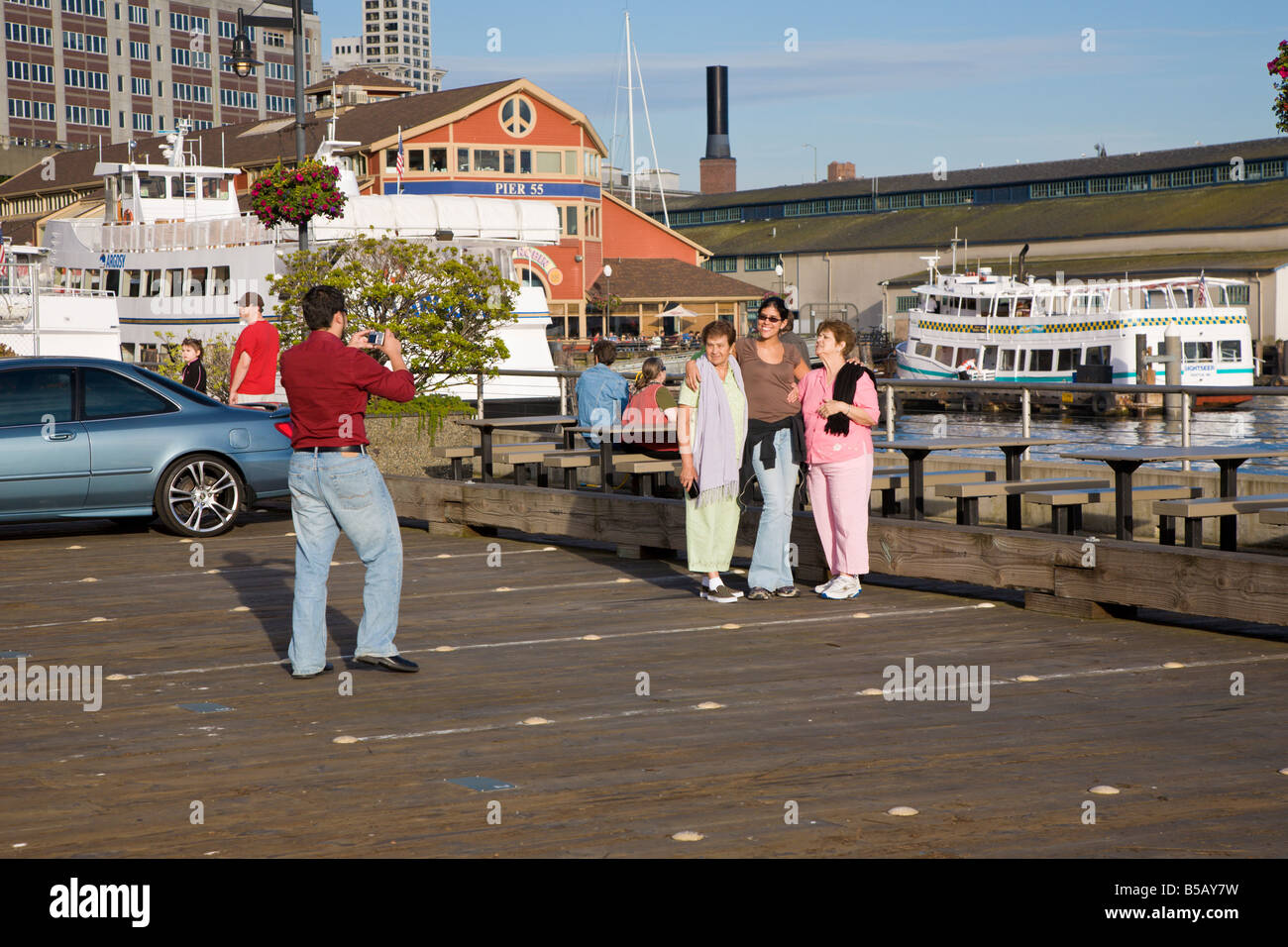 Touristen posieren für Bilder auf Dock in der Nähe von Pier 55 am Seattle waterfront Stockfoto