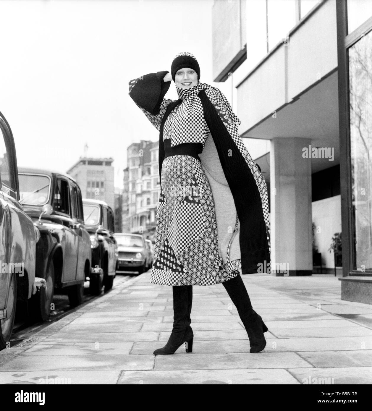 Modell trägt eine karierte und gemusterte Kleid mit passenden Rock und Knie hohe Stiefel während eines japanischen Fashion Show. April 1975 Stockfoto