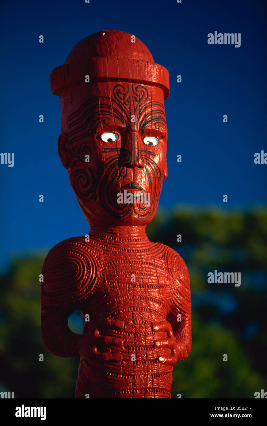 Eine geschnitzte Figur oder Poupou in einem Maori Dorf am Whakarewarewa thermal und kulturellen Bereich, Rotorua, Nordinsel, Neuseeland Stockfoto