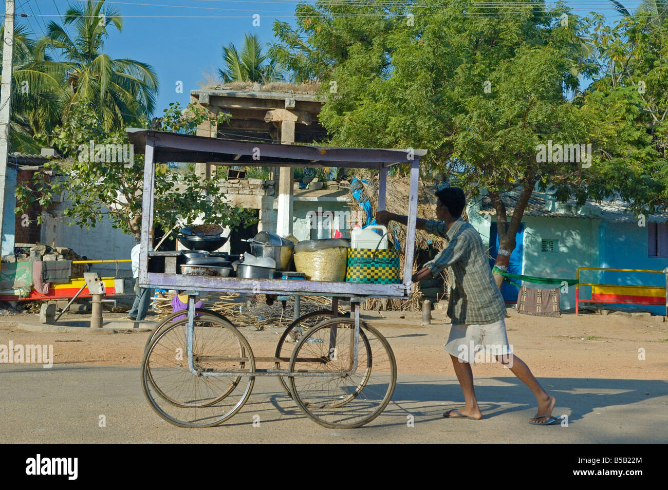 Indischer Mann schob eine typische kleine mobile Teestuben entlang Hampi Bazaar Street. Indien, Karnataka, Hampi. Stockfoto