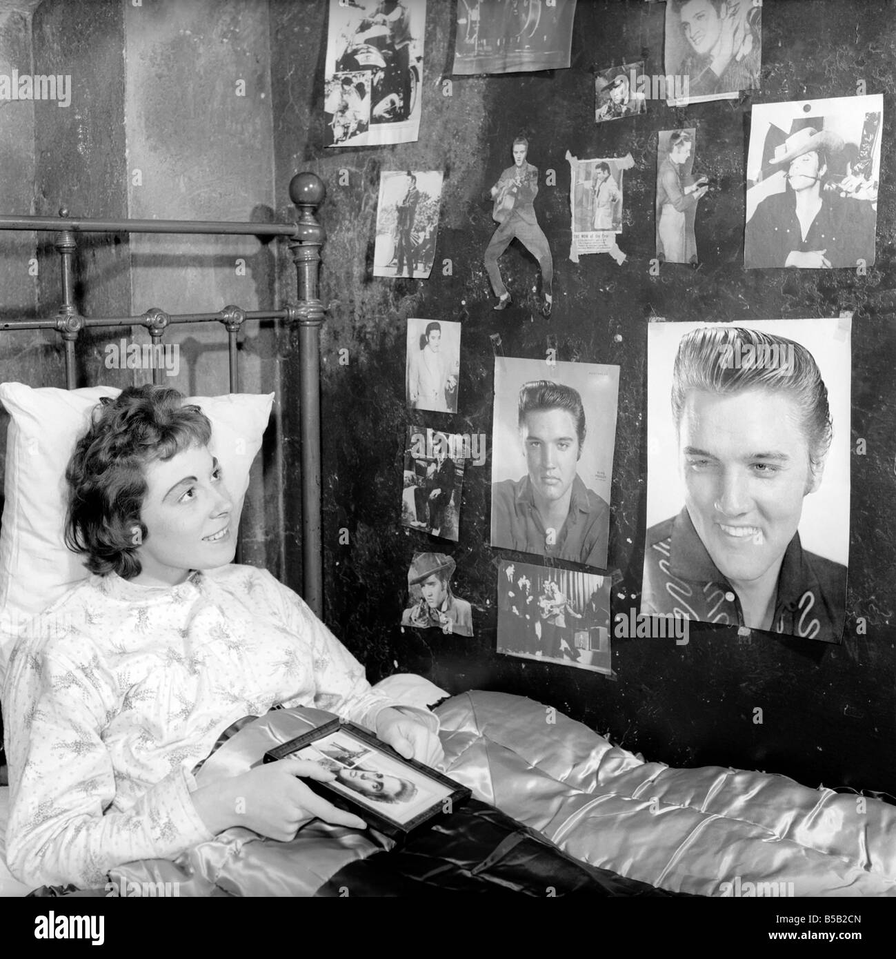 Jugendkultur: Miss Robinson, die ihr Schlafzimmer mit Bildern von Elvis Presley eingerichtet hat. Ca. 1957 Stockfoto Jugendkultur: Miss Robinson, die ihr Schlafzimmer mit Bildern von Elvis Presley eingerichtet hat. Ca. 1957 Stockfoto