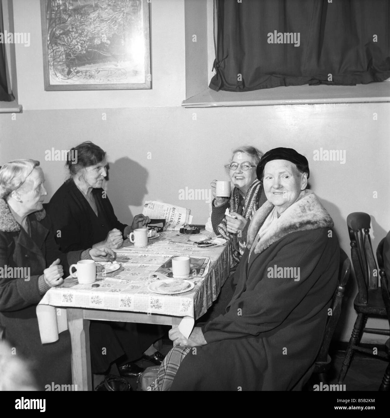 Frauen Chat, eine Tasse Tee zu teilen und den Zeitungen bei einer Frauen Herberge. 1956 Stockfoto