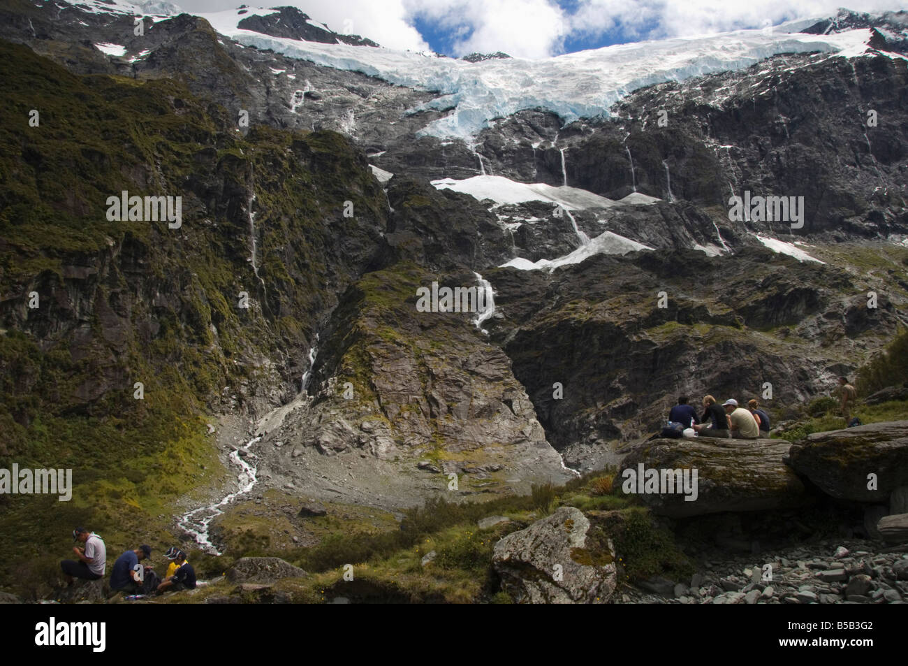 Wanderer sehen Wasser Kaskadierung von Rob Roy Gletscher, Mount Aspiring National Park, Otago, Südinsel, Neuseeland, Pazifik Stockfoto