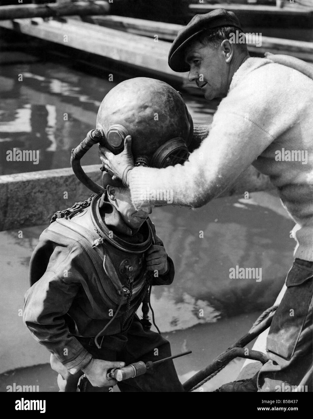 Taucher Jack Ellis mit seinem Helm aufsetzen.  
 September 1949 Stockfoto