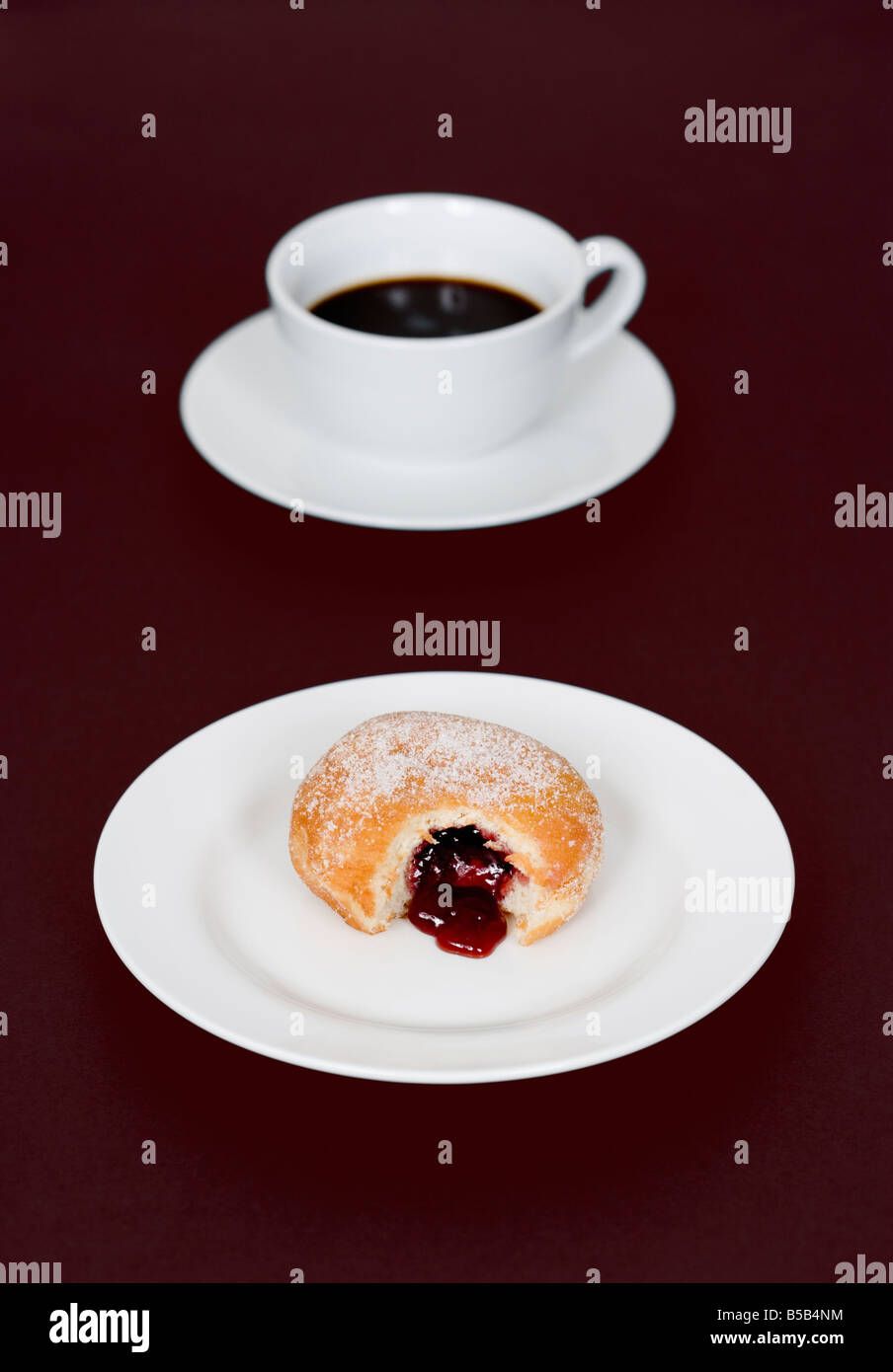 Kaffee Tasse und Marmelade Krapfen mit Biss Mark auf Platte Stockfoto Kaffee Tasse und Marmelade Krapfen mit Biss Mark auf Platte Stockfoto