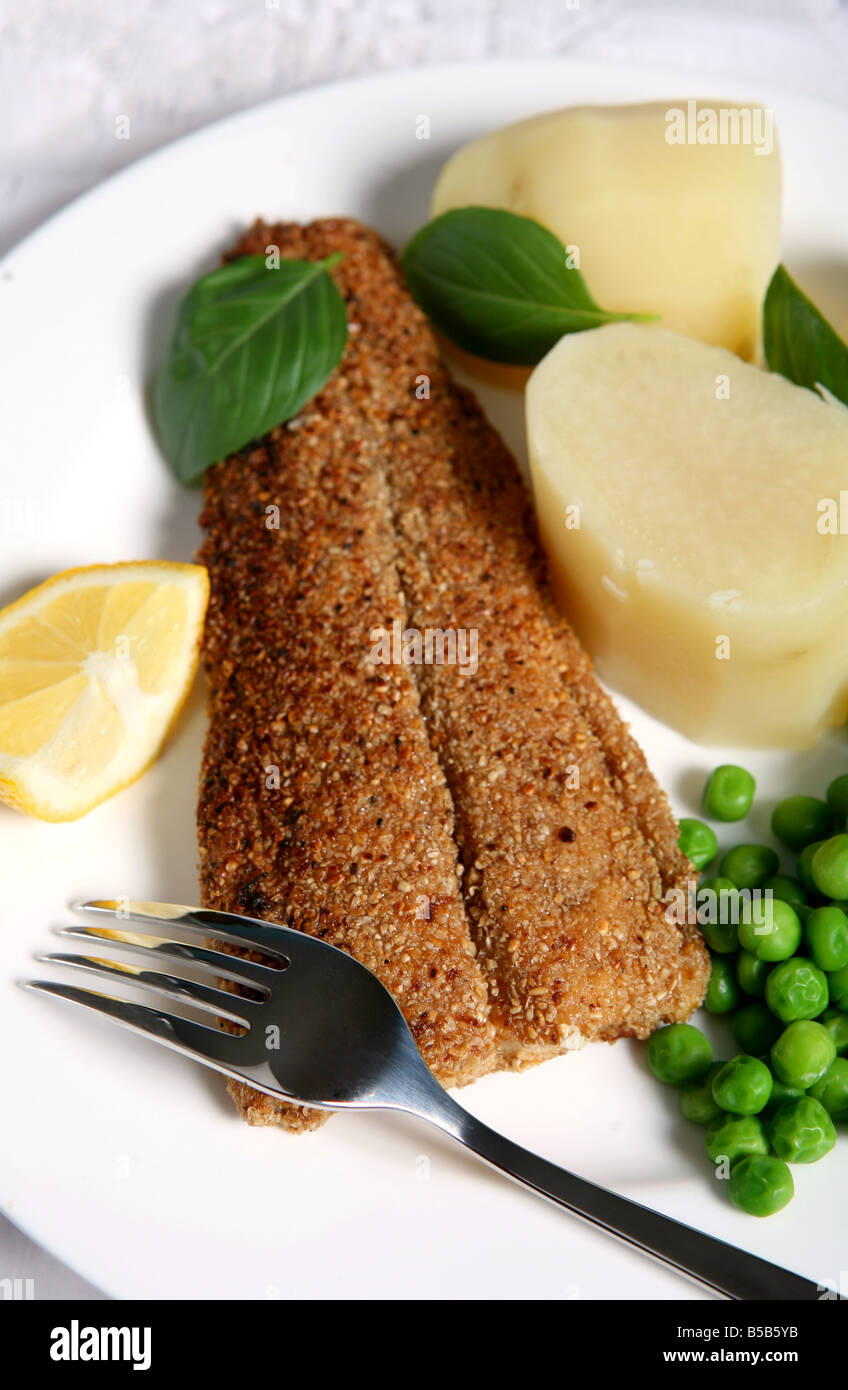 Fisch in Haferflocken, gebraten und serviert mit Salzkartoffeln und Erbsen Stockfoto