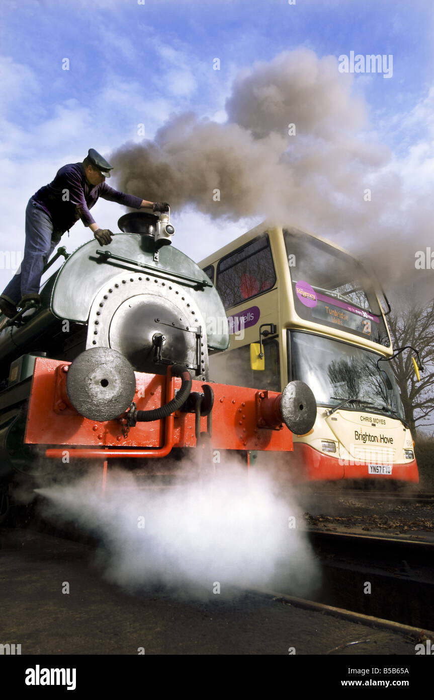 "Ein Eisenbahner passt die Lampe auf der Rauchkammer einer 1926 Saddletank Dampflok an der Lavendel-Linie in Sussex Stockfoto