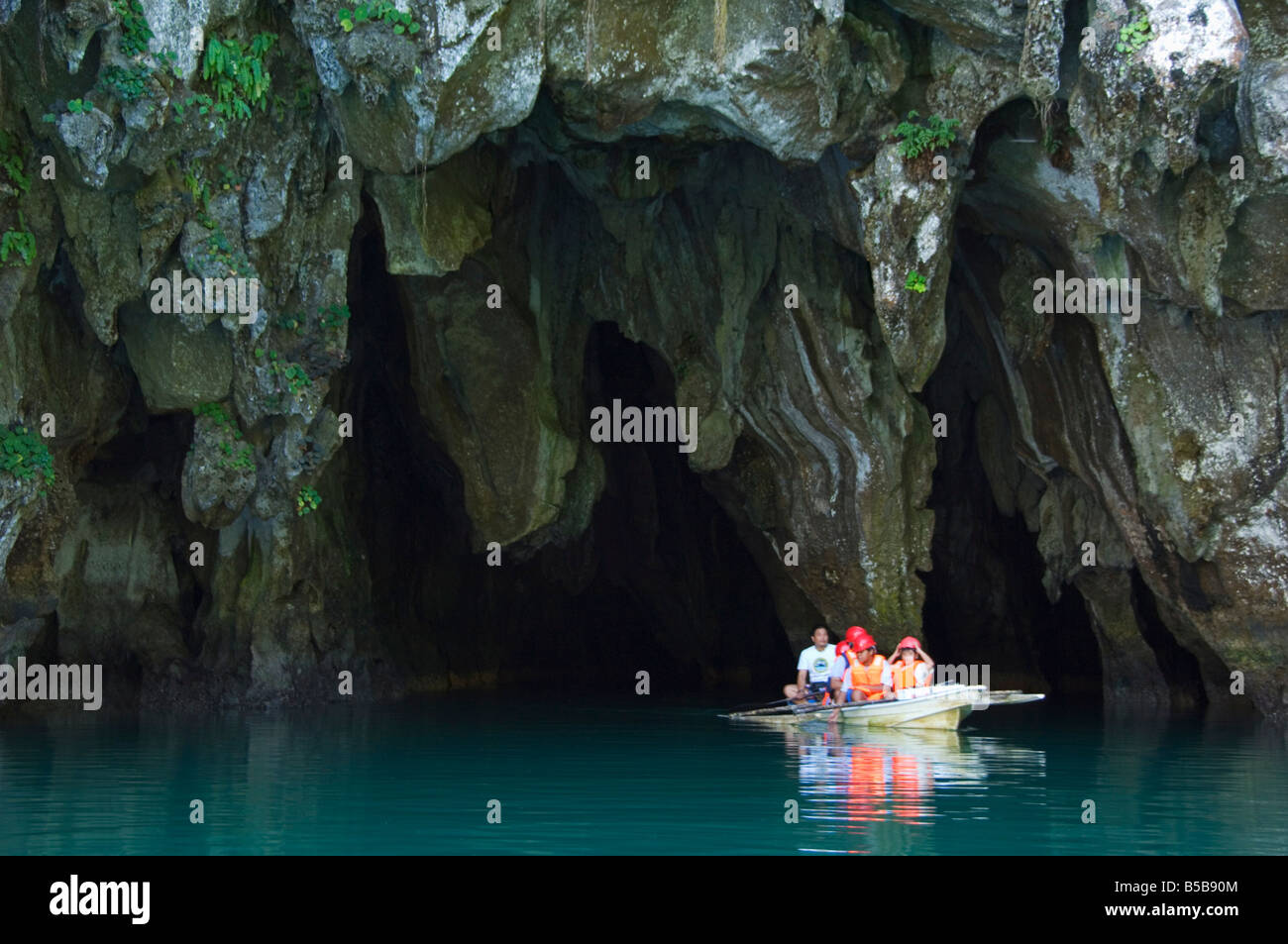 Touristen in Paddel Boot am Eingang zur Höhle Riverine, Subterranean River National Park, Stadt Sabang, Palawan, Philippinen Stockfoto