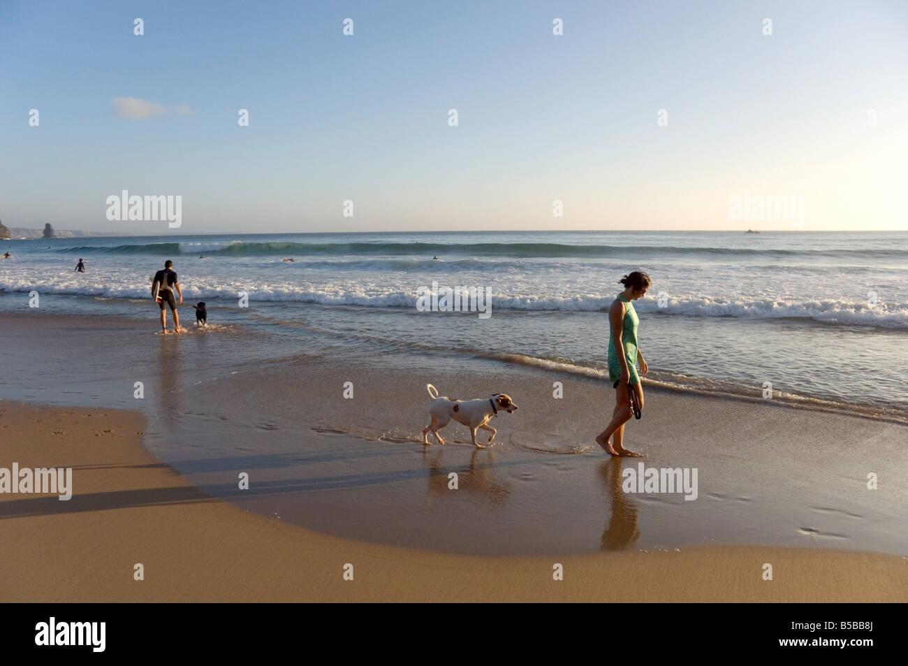 Eine junge Frau geht ihr Hund am Strand von Arrifana, Algarve, Portugal, Europa Stockfoto