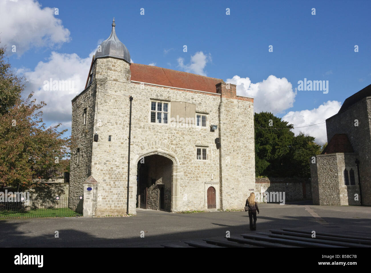 Eine Frau Besucher übergibt der Torhaus Aylesford Priory Kent in der Herbst-Sonne Stockfoto