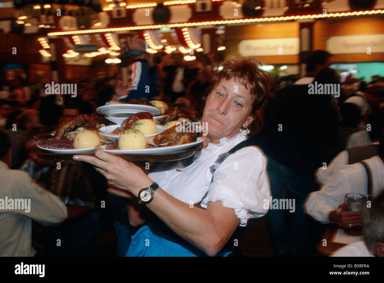 Wiesn Bierfest riesige Halle Menschen drängen sich Kellnerin Frau tragenden Tablett Essen München Stockfoto