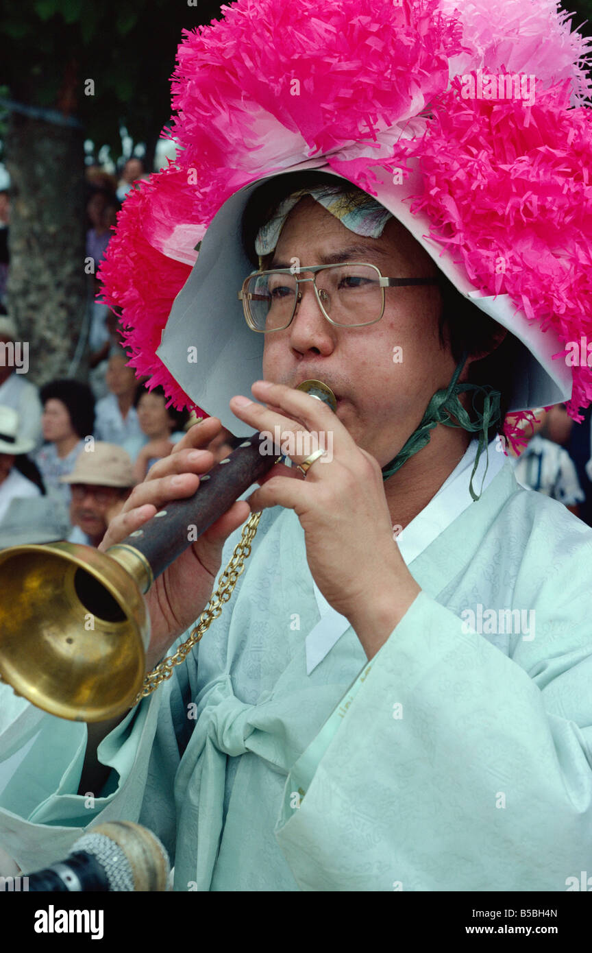Portrait eines Musikers in einen rosa Hut weht ein Instrument bei der Bauern-Tanz im Haewundae Park in Pusan City Südkorea Stockfoto