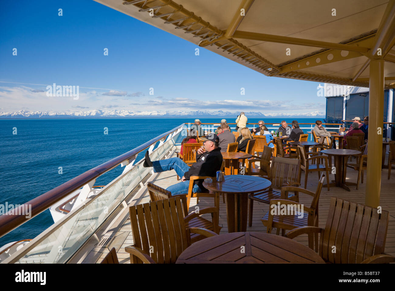 Kreuzfahrt-Passagiere auf Outdoor-Speiseterrasse beobachten schneebedeckten Berge auf Inside Passage in Alaska Kreuzfahrt besuchen Stockfoto