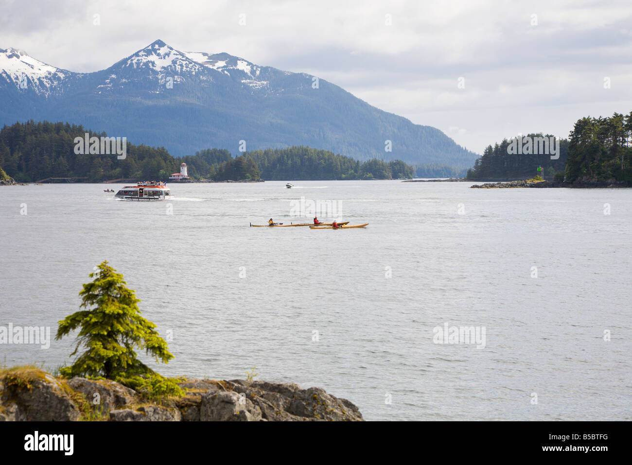 Kajakfahrer pass vor schneebedeckten Bergen und Leuchtturm im östlichen Ärmelkanal der Inside Passage in Sitka, Alaska Stockfoto