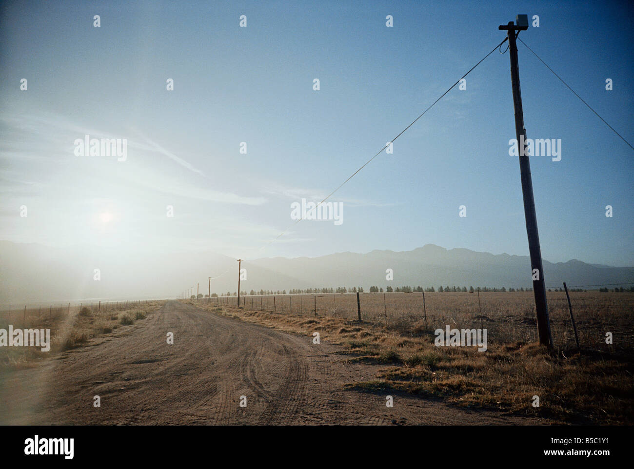 Südafrika, Northern Cape, Feldweg und Telefonleitungen bei Sonnenuntergang Stockfoto
